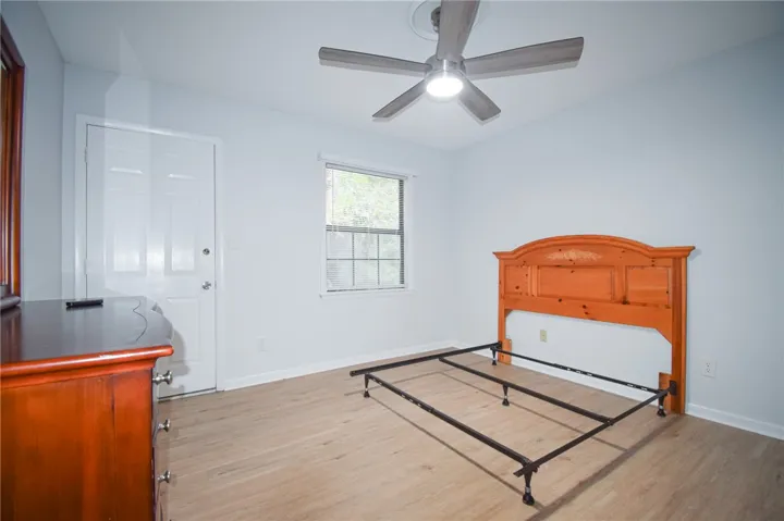 Smooth wood-look flooring and a classic multi-pane window define this versatile bedroom space.