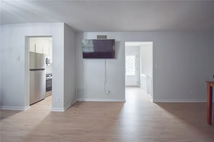 An open main floor features smooth wood-style flooring and direct sightlines to the kitchen.