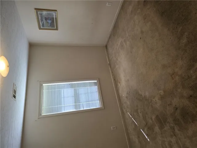 A single window provides natural light to this carpeted room.