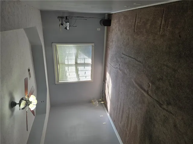 Plush carpeting anchors this versatile room boasting a tiered tray ceiling and abundant natural light.