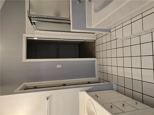 White floor tiles and matching vanity cabinets define this functional bathroom layout.