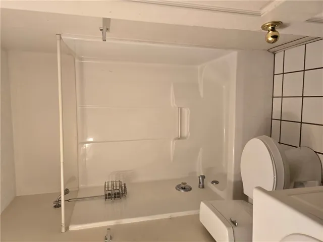 A functional bathroom configuration incorporates tiled wall accents alongside a shower and tub combination.