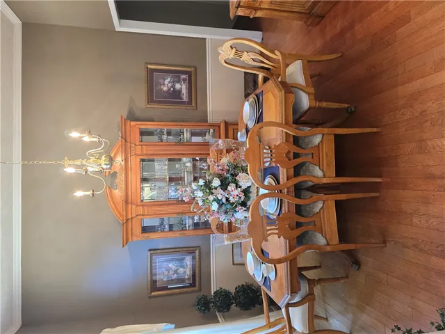 Rich hardwood flooring anchors this formal dining room featuring traditional crown molding.