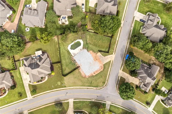 A spacious residential lot features an in-ground pool and ample green lawn space.
