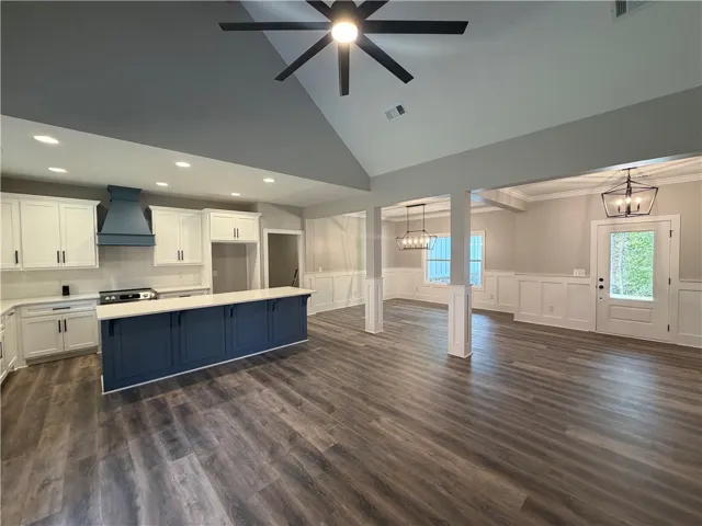 An open layout connects the kitchen to light-filled living spaces under vaulted ceilings.