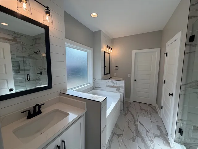 Fine marble tile runs from the floor to the surround of a deep soaking tub.