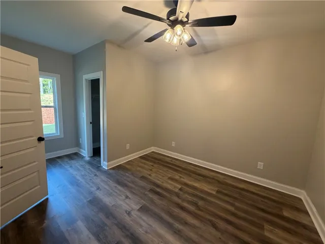 Rich wood-look flooring and a walk-in closet highlight this versatile auxiliary room.