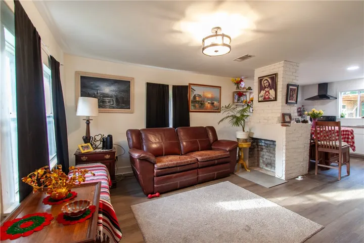 An open floor plan connects the living area with its brick fireplace to the kitchen.