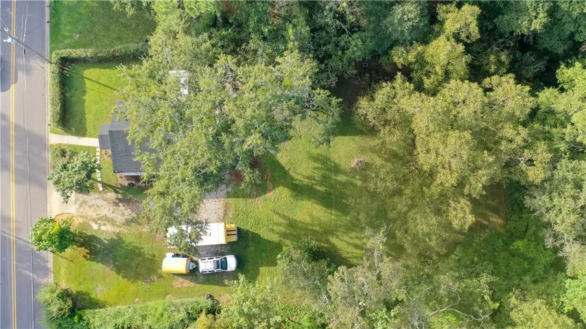 Mature trees frame a verdant lawn on this expansive aerial view.