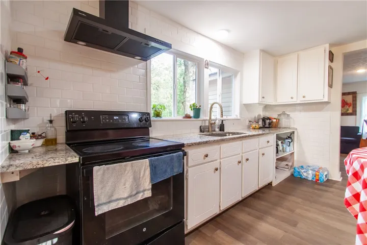 Gleaming stone countertops and a modern range hood anchors this practical culinary workspace.