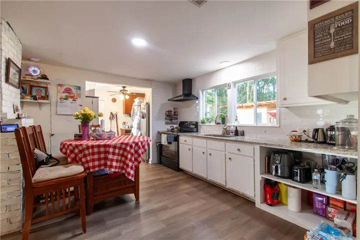 Natural light streams through wide windows over long stone countertops in this spacious culinary workspace.