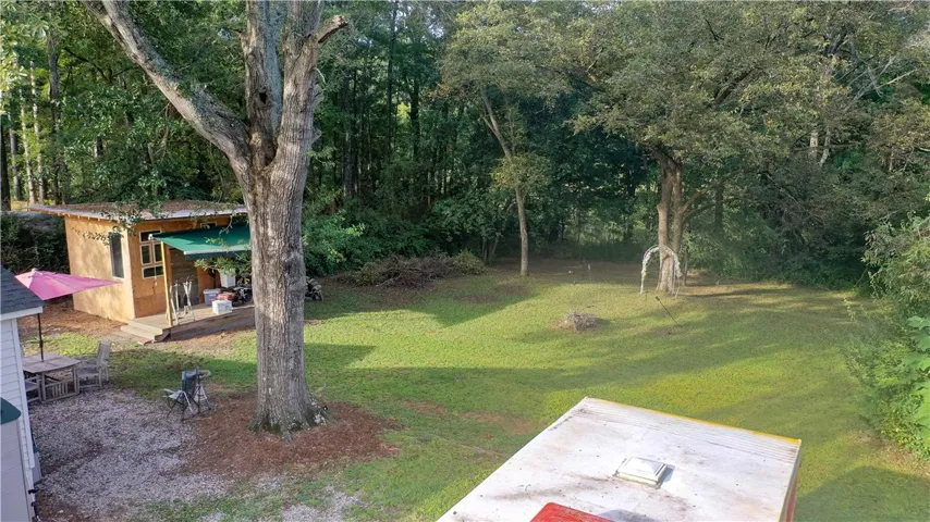 Mature trees frame a spacious grassy backyard offering a quiet natural escape.