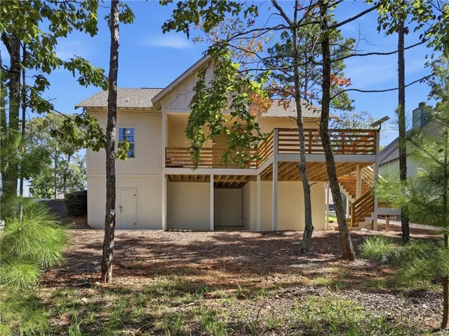 Mature trees frame the elevated wooden deck and clean exterior lines of this modern home.