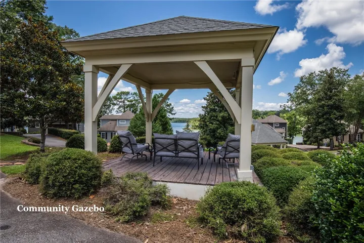 An open-air pavilion overlooks the water amidst lush landscaping and mature trees.