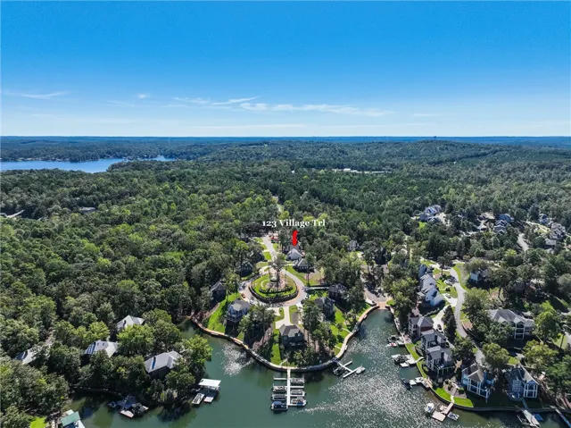 Lush forested hills frame this lakeside community under clear blue skies.