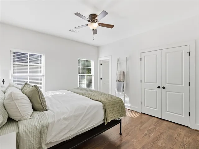 Warm hardwood floors and abundant natural light create a serene, inviting atmosphere in this bedroom.