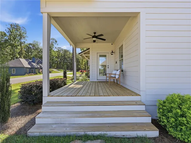 Inviting exterior steps lead up to a covered wooden porch with a private entrance.