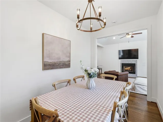 An open floorplan seamlessly connects the dining space to the adjacent fireplace-centered room.