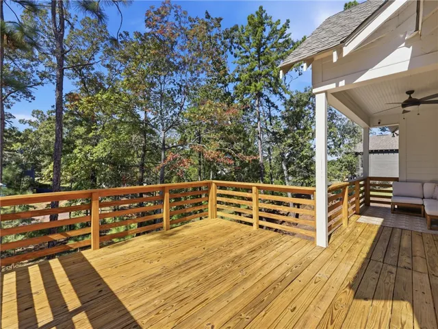 Mature trees provide a serene natural backdrop for this spacious elevated wooden deck.