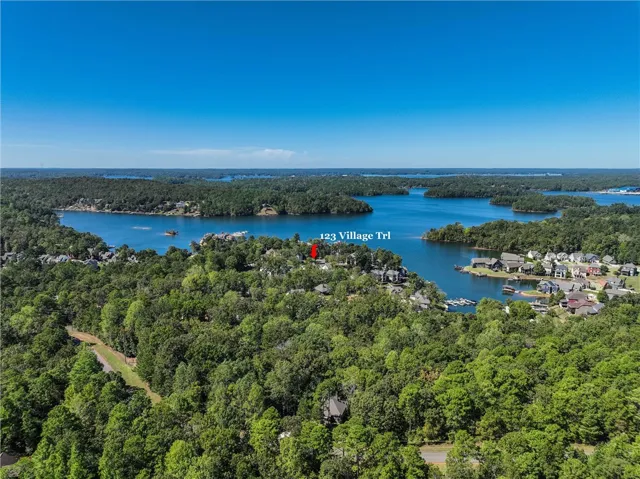 Lush woodlands surround this lakeside setting under expansive blue skies.