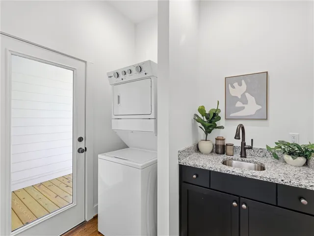 Granite counters and hardwood floors elevate this practical laundry space featuring direct outdoor access.