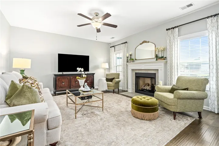 A cozy fireplace anchors this inviting living space finished with rich hardwood flooring.