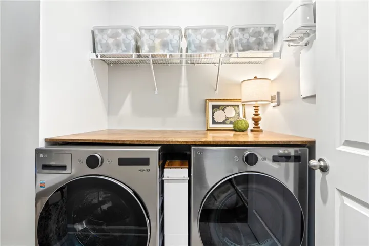 A customized wooden folding counter fits perfectly above the modern laundry appliances.