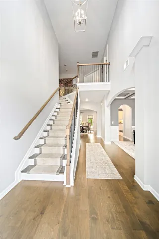 Gleaming hardwood floors and a soaring ceiling welcome visitors into a dramatic two-story entry.
