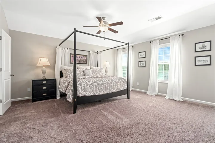 Generous natural light streams through multiple windows in this comfortable main level bedroom.