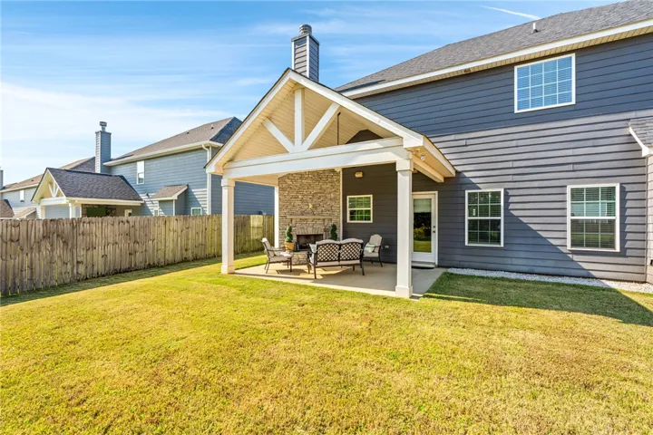A spacious covered patio anchors the private backyard, complete with a stone fireplace.