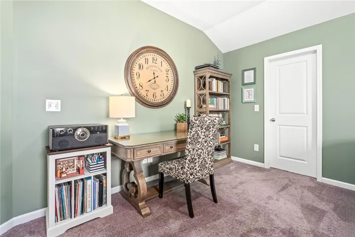 A vaulted ceiling and soft-toned walls define this versatile home office space.