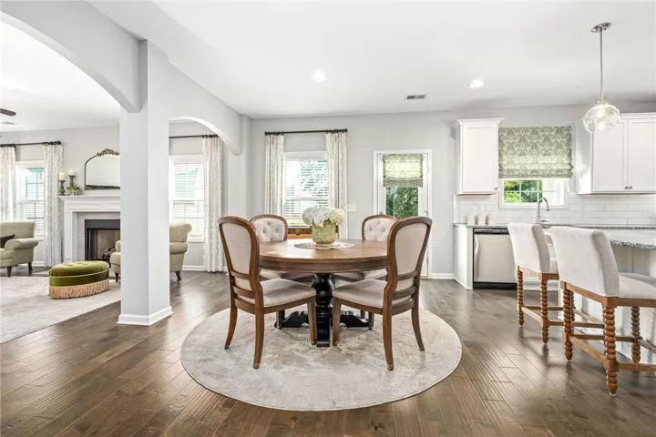 Gleaming hardwood floors and classic arched transitions connect this comfortable dining area to nearby living spaces.