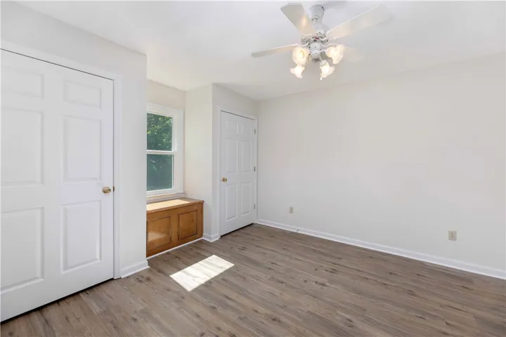 Warm wood flooring and built-in window seating anchor this versatile secondary space.