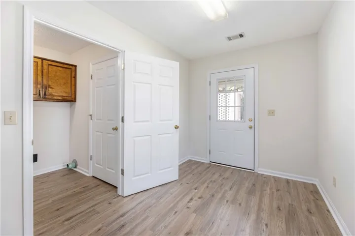 Durable laminate flooring runs throughout this versatile entryway and utility space.