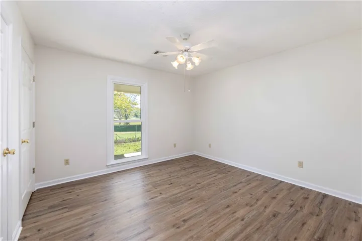 Rich wood-inspired floors anchor this versatile room framing a pleasant view of the green yard.
