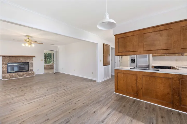 Rich wood floors seamlessly connect the open-concept living area to the adjacent kitchen.