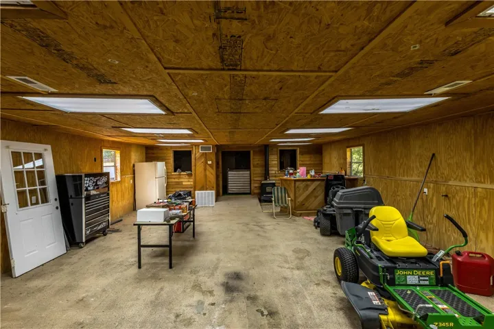 An expansive outbuilding showcases wood-paneled walls and a durable concrete floor.
