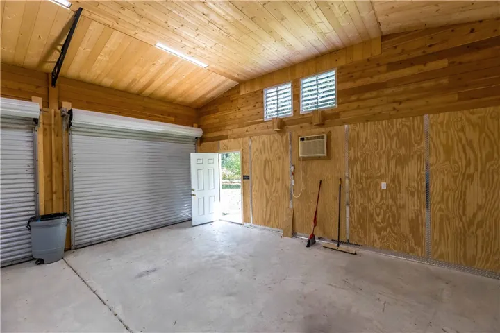 Natural wood paneling pairs with durable concrete flooring inside this versatile, vaulted workspace.