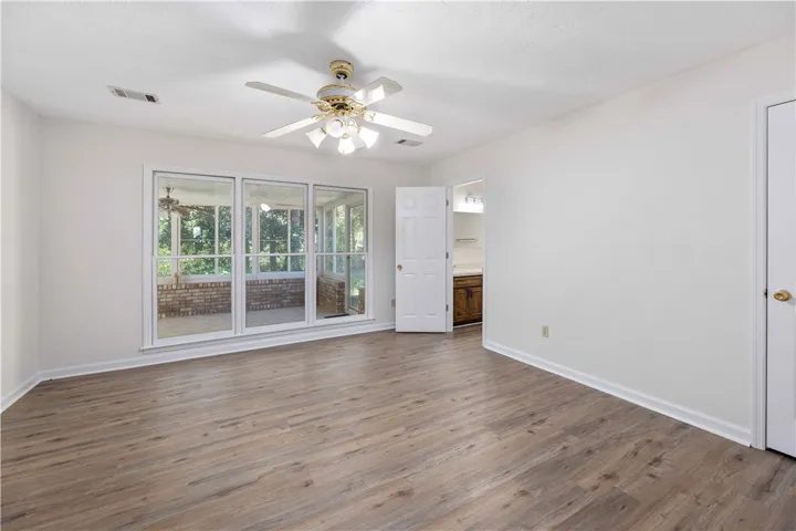 Gleaming wood-look floors anchor this airy room featuring large windows overlooking the sunroom.