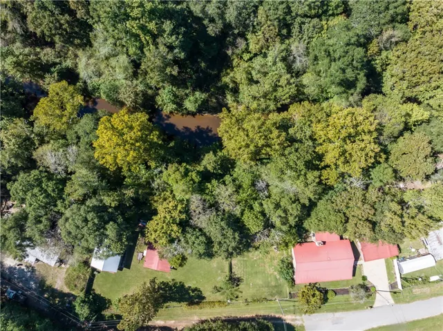 Mature trees surround the property, providing natural shade and a scenic river border.