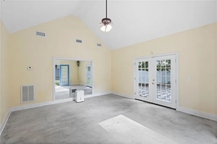Vaulted ceilings and double glass doors define this versatile space featuring durable concrete flooring.