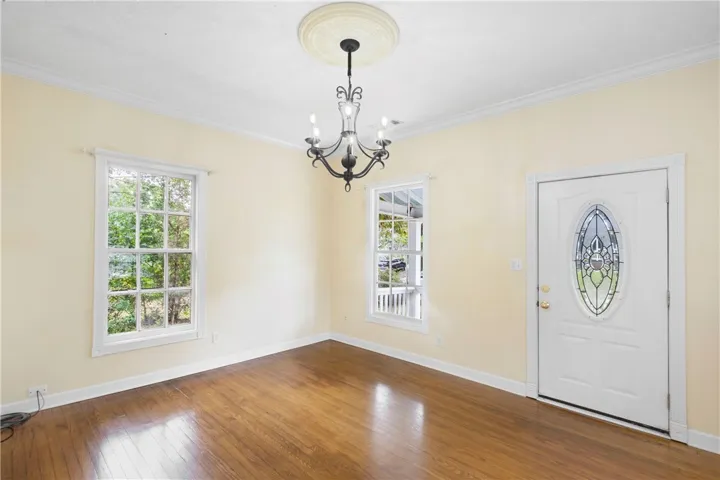 Polished hardwood floors and classic crown molding frame a bright, welcoming entry space.