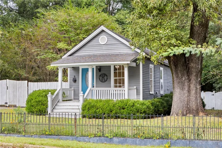 A welcoming front porch leads into this classic cottage surrounded by mature trees.