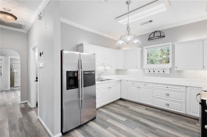 Ample cabinetry and durable wood-look flooring anchor this spacious kitchen design.