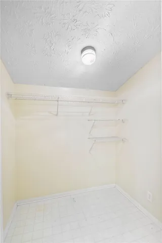 Ample wire shelving and tiled flooring define this practical walk-in storage area.