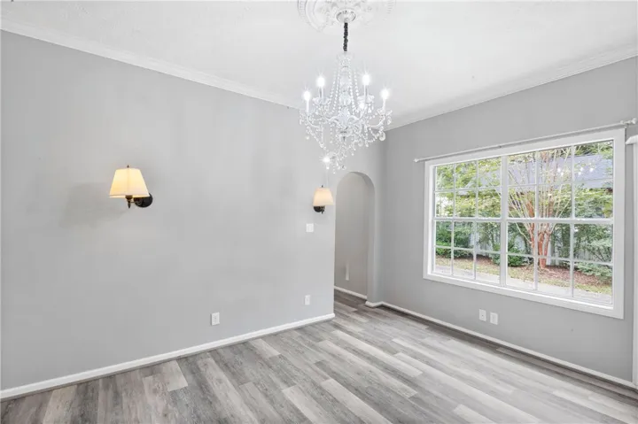 Crown molding and wide windows complement the modern plank flooring.