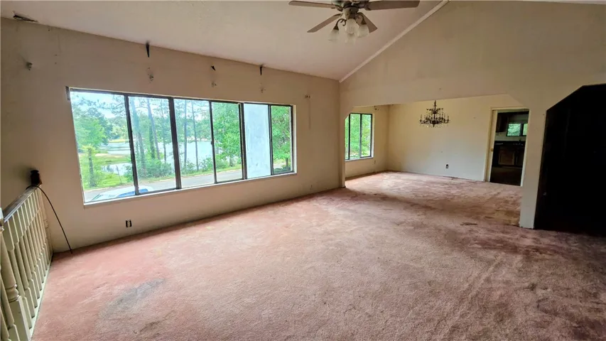 Vaulted ceilings and broad windows frame peaceful water views in this open-concept space.