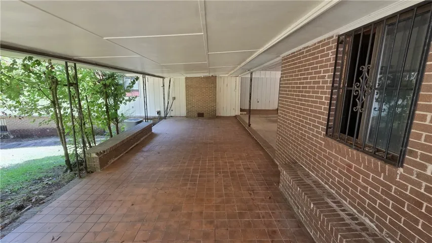 An expansive covered patio features classic brick walls and durable tile flooring.