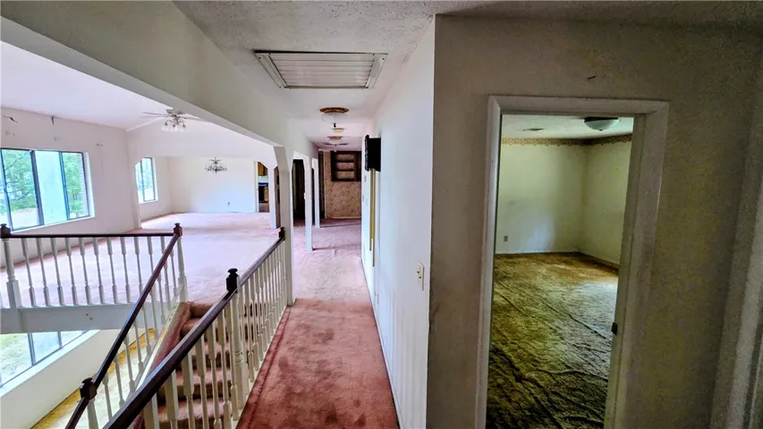 A spacious upper-level landing connects various rooms while overlooking the lower living areas.