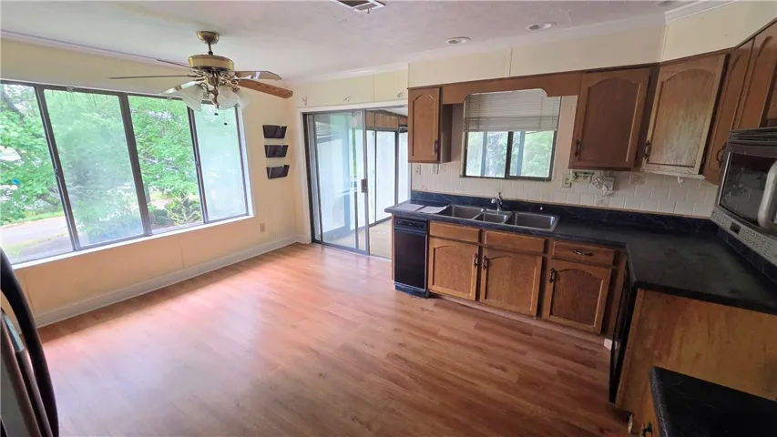 Rich wood flooring pairs with classic wood cabinetry and sliding glass doors leading outdoors.